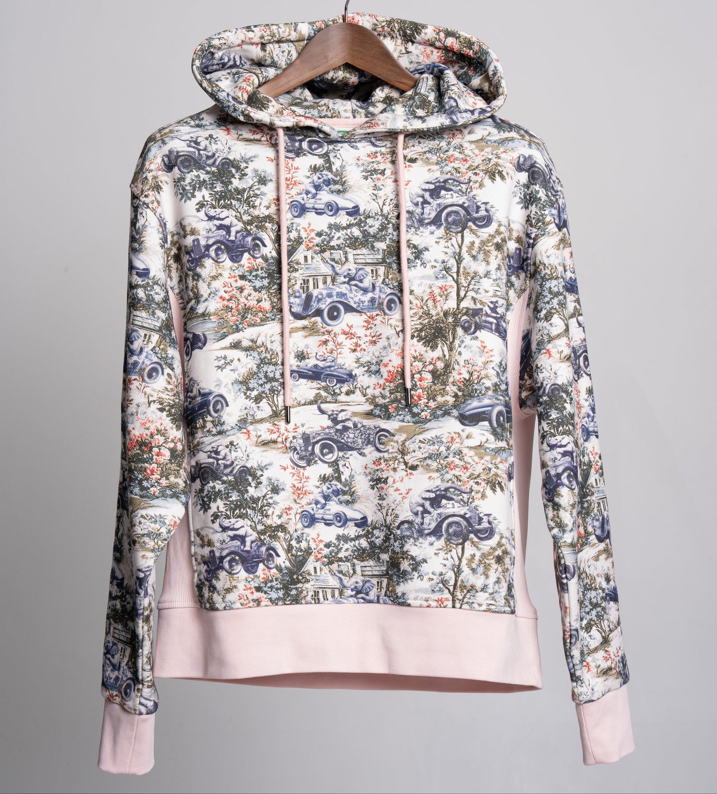 Floral and car patterned toile hoodie on a gray background